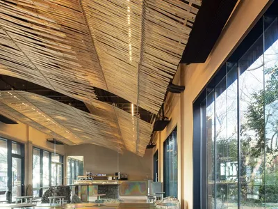 Modern restaurant interior with a bar, dining area, and ample seating options, featuring bottles and a welcoming atmosphere