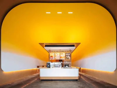 A restaurant dining area with a counter and chairs, featuring a warm and inviting atmosphere