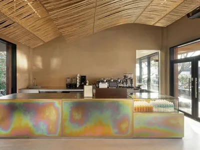 A casual coffee shop interior with a counter, sinks, and various items on display, creating a welcoming atmosphere for customers