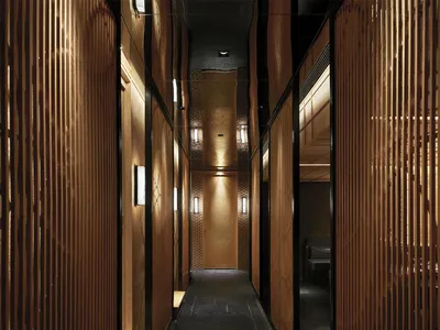 A modern hotel lobby with wooden walls and floors, featuring two benches and a functional design