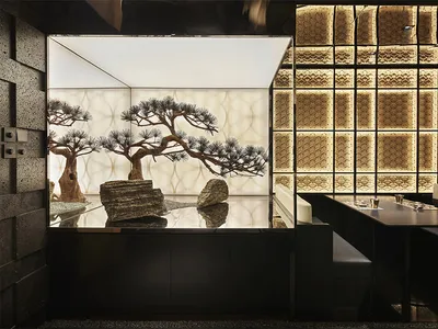 餐廳內部設有大型盆栽樹置於玻璃櫃中，周圍環繞座椅與酒杯，營造優雅而溫馨的氛圍