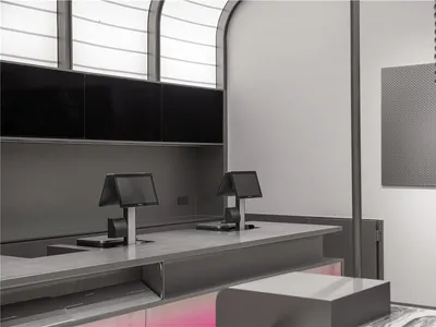 An empty restaurant counter with two cash registers and a metal surface, giving a modern and sleek appearance