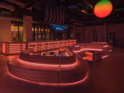 A cozy bar lounge with a circular table surrounded by chairs and couches, creating a relaxed atmosphere for socializing and leisure time