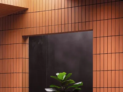 窗前擺放盆栽綠樹的家用辦公室，配有兩把椅子與餐桌