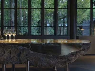 A sophisticated dining area with a glass table, wine glasses, and inviting ambiance