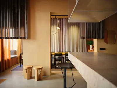 溫馨餐廳內部，設有木質吧台、椅子、餐桌與盆栽，營造出適合社交與用餐的舒適氛圍