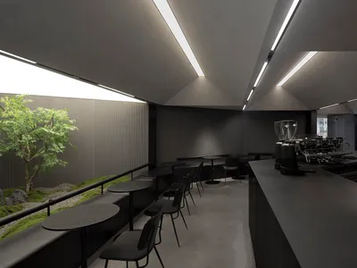 空蕩蕩的暗黑餐廳內部，黑色牆面與餐桌，椅凳環繞用餐區