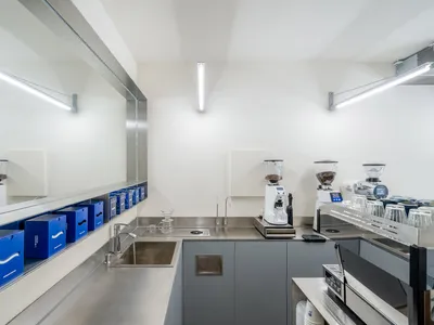 光線充足的現代廚房，配備不鏽鋼檯面、水槽與家電
