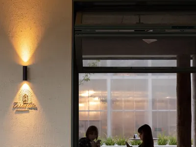 A casual dining area with wooden furniture, people socializing and enjoying a meal together