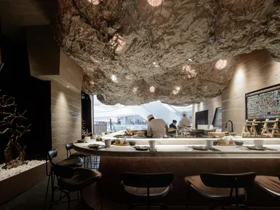 Inviting restaurant interior with a bar, stools, chairs, and dining tables, featuring a mix of hot and cold beverages and meals