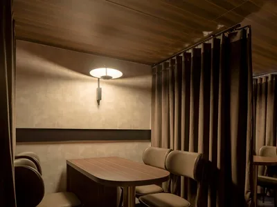Dimly lit dining space with modern chairs and tables, creating a cozy atmosphere