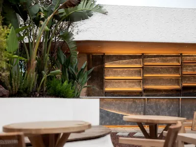 Casual dining area with a wooden counter, metal chairs, and two dining tables