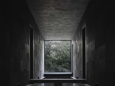 Indoor pool area with stone walls, two benches, and a luxurious atmosphere