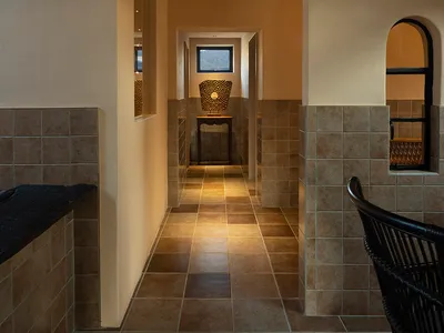 A clean and modern hallway with a tiled floor, two chairs, and a dining table, creating a comfortable and inviting atmosphere