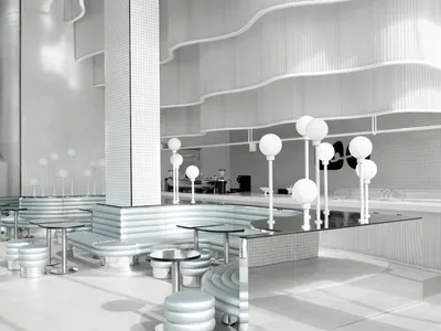 An empty restaurant interior with white walls, dining tables, and chairs, giving a clean and well-organized atmosphere