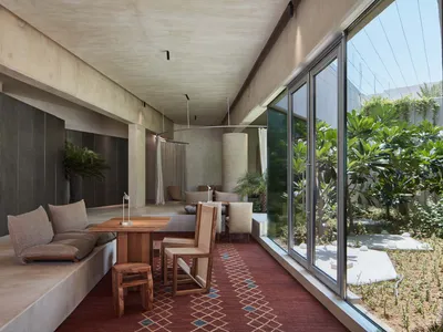 Cozy open concept living space with a red carpet, two couches, chairs, and a dining table, creating a warm and inviting atmosphere
