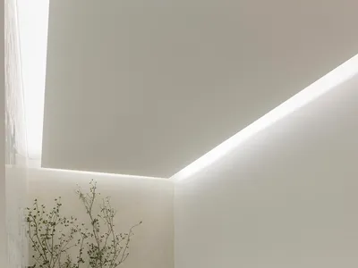 Empty restaurant interior with white walls, grey benches, and modern chairs, featuring dim lighting and a clean, minimalistic atmosphere