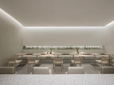 空蕩蕩的餐廳內部，設有多張餐桌椅，融合工業與現代設計元素