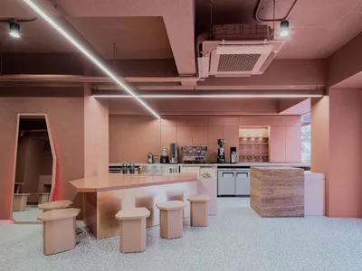 Warm and inviting restaurant space with wooden floors and walls, featuring a dining table and chairs, and decorative cups and bottles
