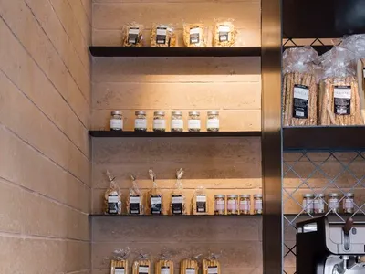 廚房場景，料理檯上陳列各種食物、瓶子、杯子與碗盤，背景為中性色調