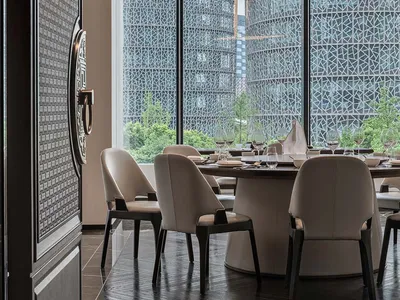精緻餐廳空間，設有大型餐桌準備用餐，周圍環繞座椅與酒杯