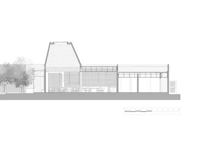 一座現代餐廳建築，呈現兩層樓三角造型，融合混凝土、玻璃與木材，並配有戶外座椅區