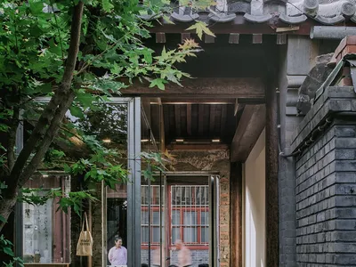 居家內部空間，設有餐桌與椅子，杯子散置四周，兩人站在門口附近