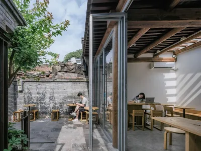 A casual dining area with multiple tables and chairs, featuring a mix of seating arrangements and a relaxed atmosphere