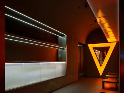 A hotel hallway with wooden paneling, benches, and a welcoming atmosphere
