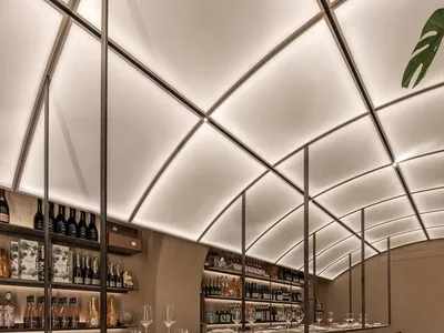 精緻的用餐空間，設有長桌準備好用餐，周圍環繞座椅與葡萄酒瓶