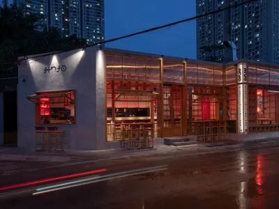 A modern Asian restaurant at night with red accents, natural light, and comfortable seating for guests