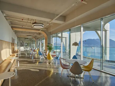 Spacious restaurant interior with natural light, wood tables, and seating areas