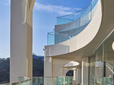 A modern hotel lobby with glass walls, clean lines, and minimal decoration, flooded with natural light and featuring high-end design elements