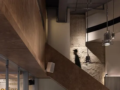 一間溫馨的咖啡店，設有樓梯、椅子、餐桌與盆栽，營造出溫暖的氛圍