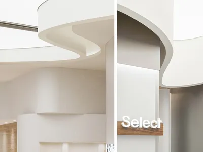 Clean and welcoming hotel lobby with white walls, curved ceiling, and wooden elements