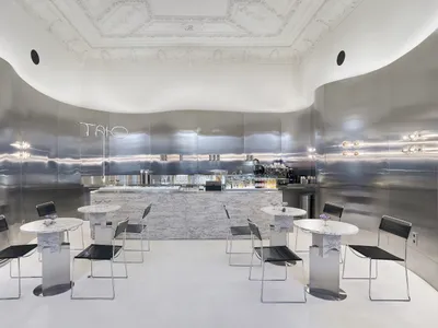 Sophisticated restaurant interior with white marble walls, wine glasses, and comfortable seating areas