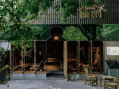現代亞洲餐廳擁有寬敞用餐區、椅子與長椅，周圍環繞自然元素並具備充足採光室內設計
