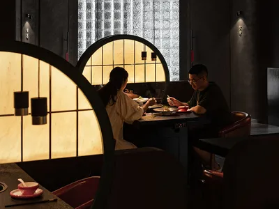 A cozy restaurant interior with a wooden table and metal accents, featuring comfortable seating and warm lighting