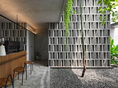 A modern restaurant bar with a brick wall, a countertop, and three chairs, creating an inviting atmosphere for dining and socializing