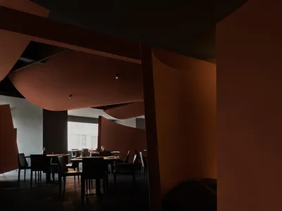 A warm and inviting dining space with a large table, red walls, and wine glasses, perfect for socializing and dining