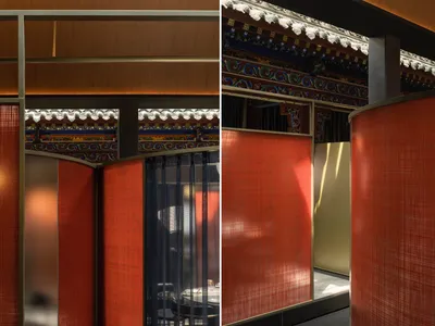 Dining area with tables and chairs in an Asian restaurant featuring red and gold walls, orange curtains, and decorative vases