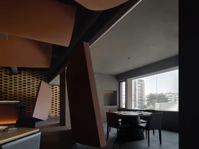 Modern restaurant interior with red and brown walls, natural light, and seating areas