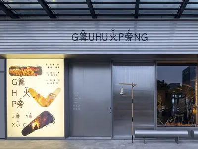 一間店面擁有大型展示窗，陳列腳踏車及其他物品，店外有兩張長椅，店內有盆栽