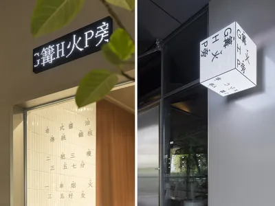 木質立面的店面，上方有招牌，周圍擺放盆栽植物
