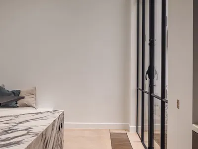 Empty living room with white walls and a large window, two couches, and natural light from the window