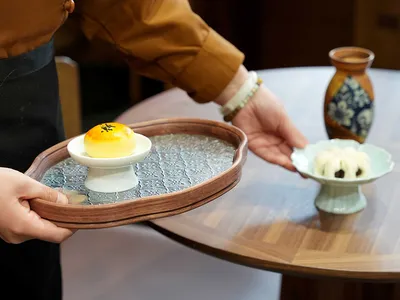 餐廳內燈光明亮的餐桌，擺放兩盤食物與兩杯飲料，強調餐桌在場景中的核心地位