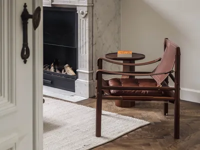 Cozy living area with a fireplace, two chairs, and a dining table, set in a warm and inviting atmosphere