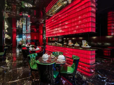 紅牆綠椅溫馨餐廳內部，配有餐桌、碗具與座椅