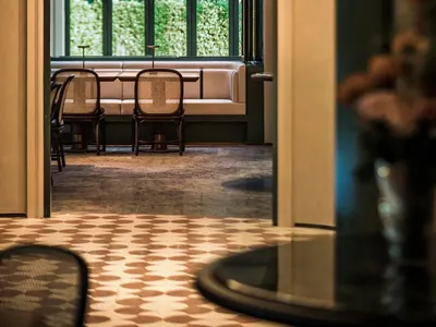Dining area with a large archway, two chairs, and a dining table surrounded by chairs, giving off a sophisticated atmosphere