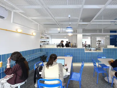 木桌椅、盆栽與用餐社交的人群，充滿活力的餐廳內部